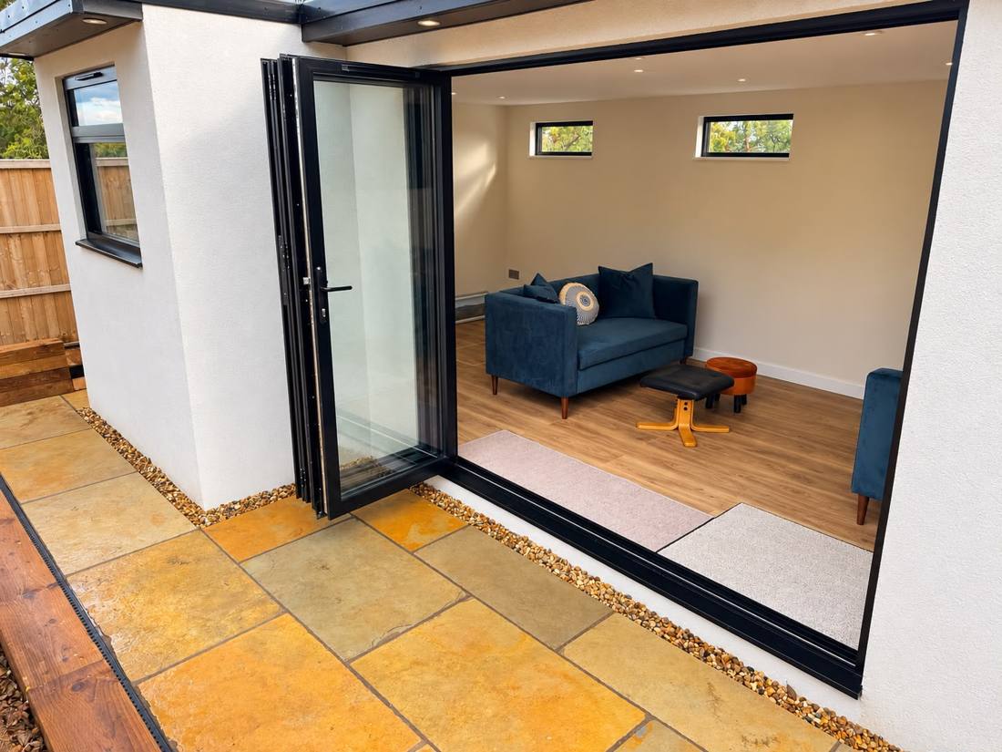 Bi-fold doors folded open onto sandstone patio