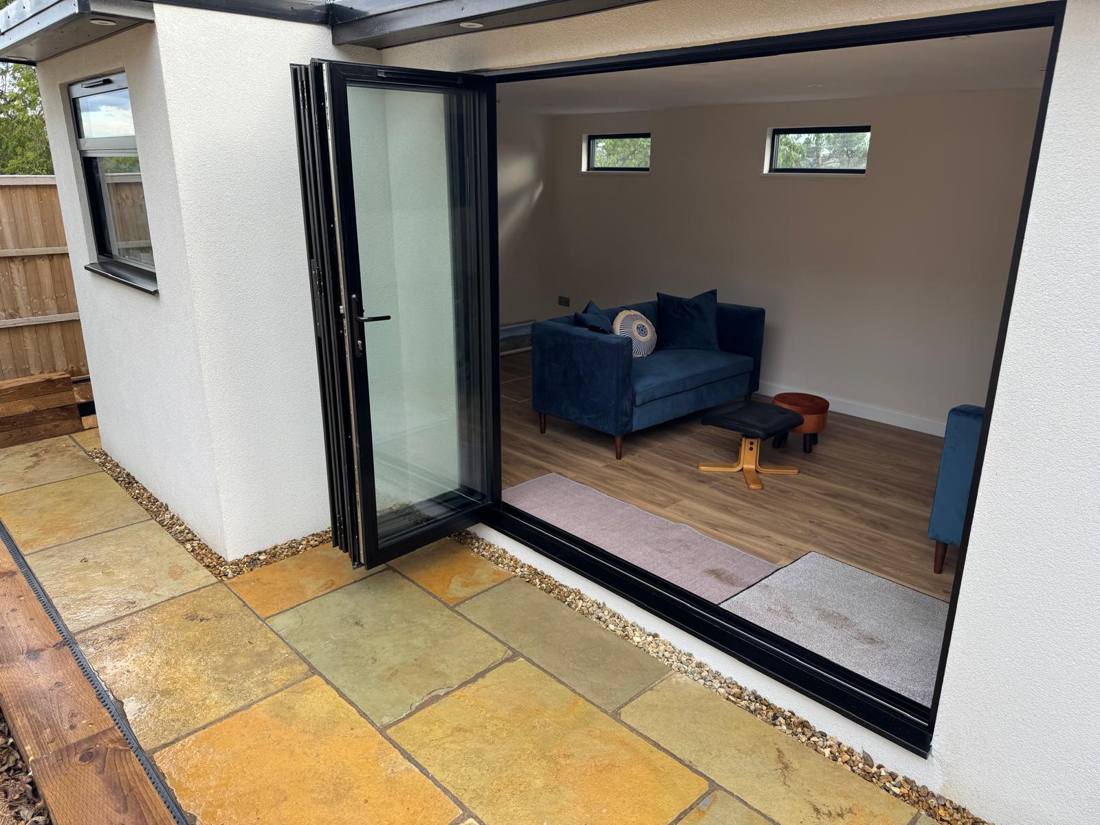 Bi-fold doors opening onto a sandstone terrace