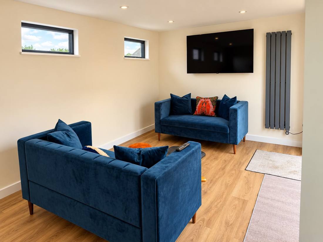 Interior with blue velvet sofas, wall TV and radiator