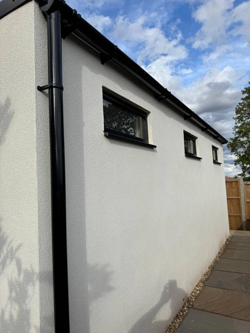 Rendered side wall with clerestory windows and black guttering